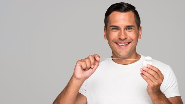 Medium shot man holding dental floss