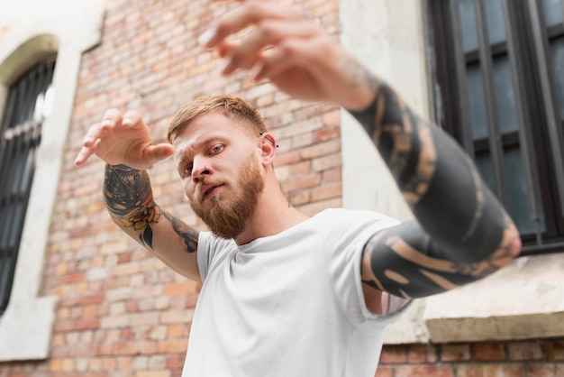 Medium shot man with tattoos posing