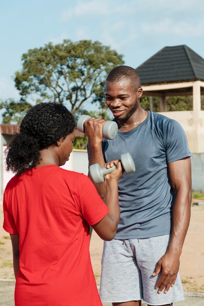 Medium shot man and woman with dumbbells