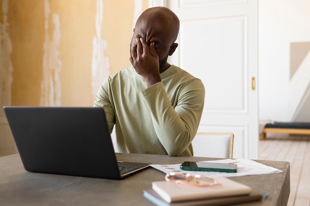 Medium shot man working on laptop