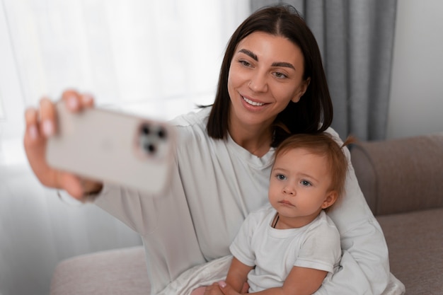 Medium shot mother and baby taking selfie