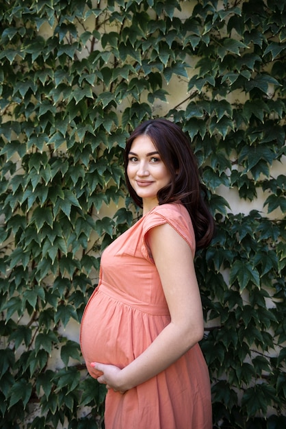 Medium shot pretty pregnant woman posing outdoors