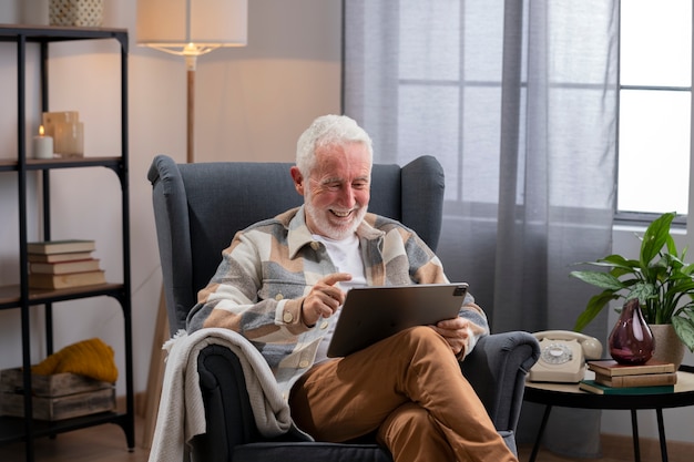 Medium shot senior man holding tablet