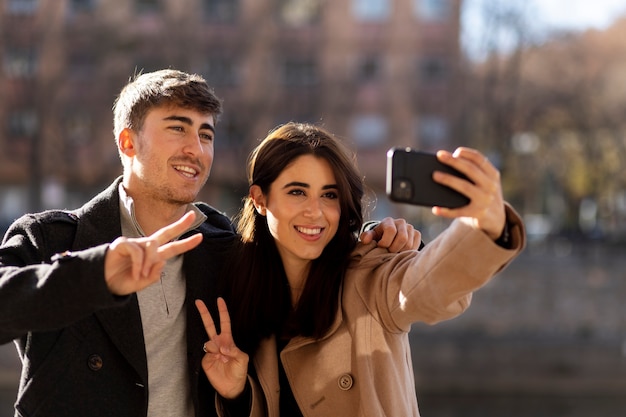 Medium shot smiley couple taking selfie