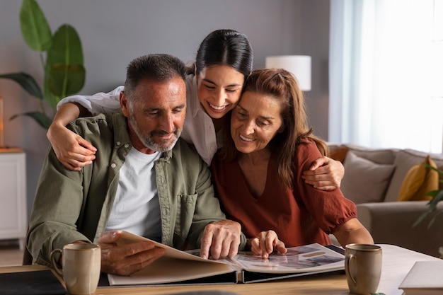 Medium shot smiley family looking at picture album