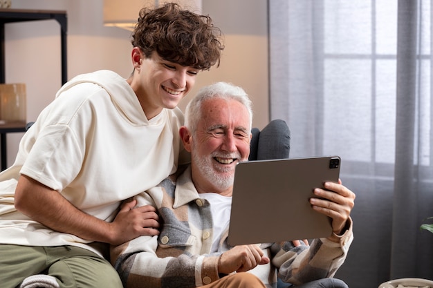 Medium shot smiley kid and man with tablet