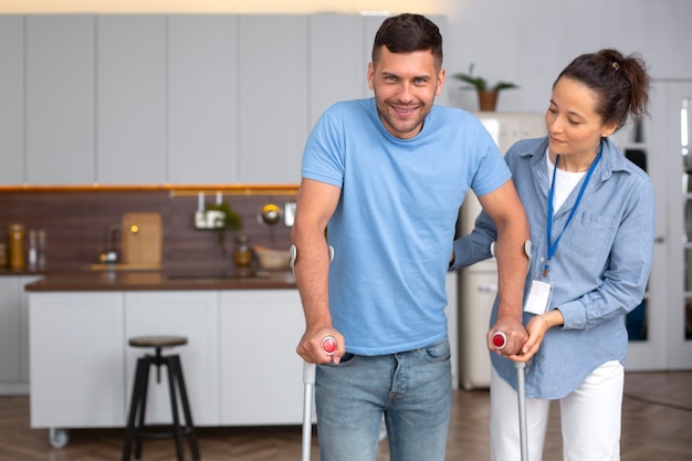 Medium shot smiley man walking with crutches