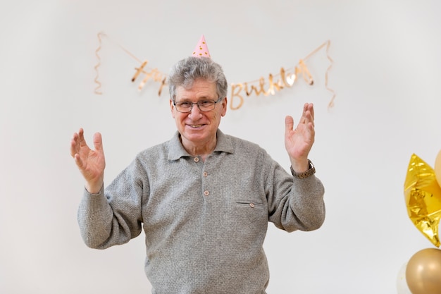 Medium shot smiley man wearing party hat