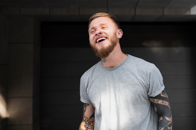 Medium shot smiley man with tattoos