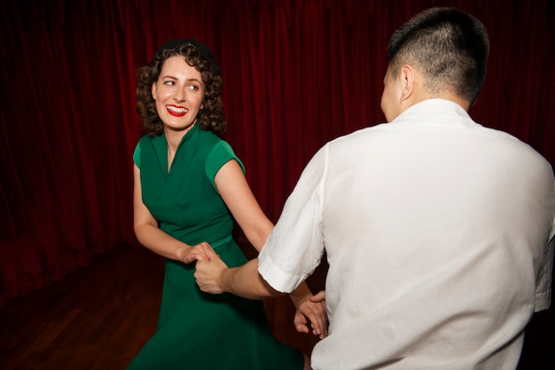 Medium shot smiley partners swing dancing