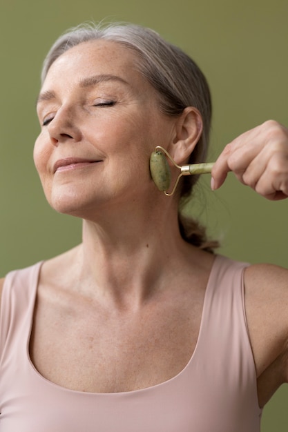 Medium shot smiley woman massaging face