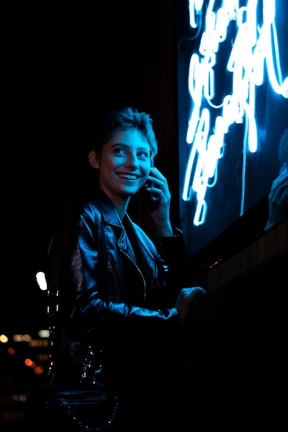 Medium shot smiley woman and neon light