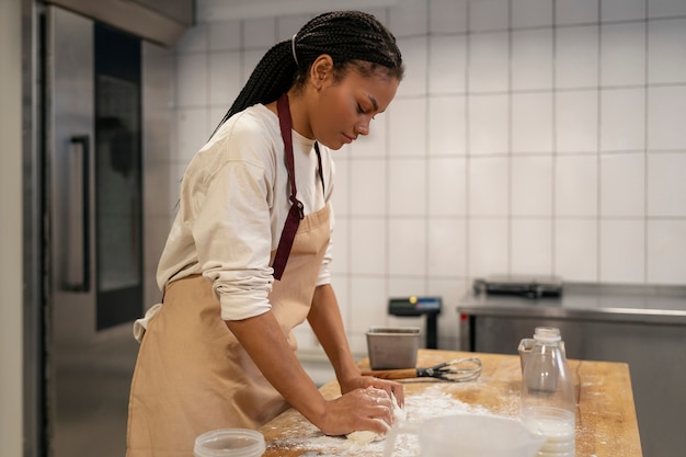 Medium shot woman baking in kitchen