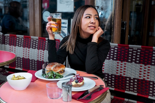 Medium shot woman at bistro with drink