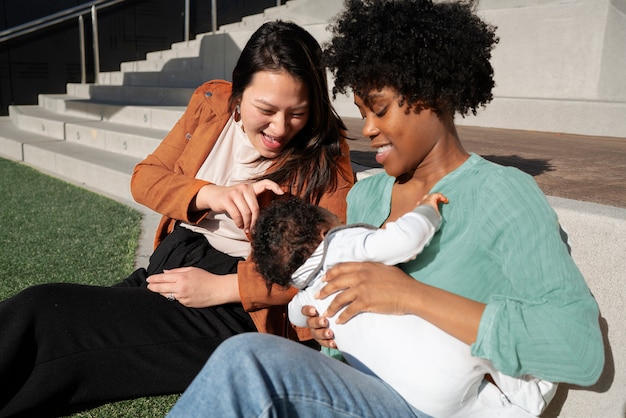 Medium shot woman breastfeeding baby in public