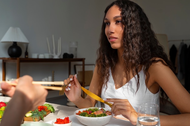 Medium shot woman eating salmon bowl