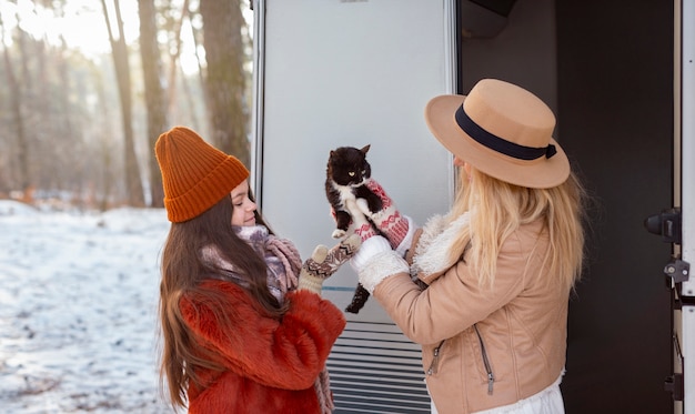 Medium shot woman and girl holding cat