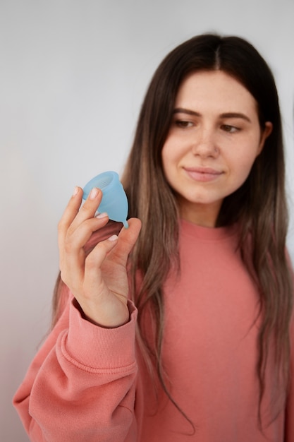 Medium shot woman holding menstrual cup