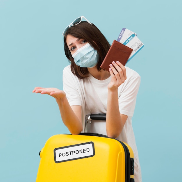 Medium shot woman holding plane tickets and yellow baggage