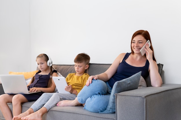 Medium shot woman and kids with devices