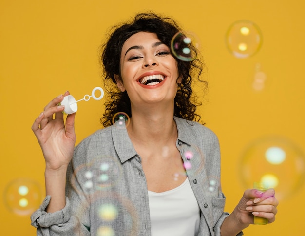 Medium shot woman making soap bubbles