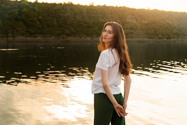 Medium shot woman posing by the lake