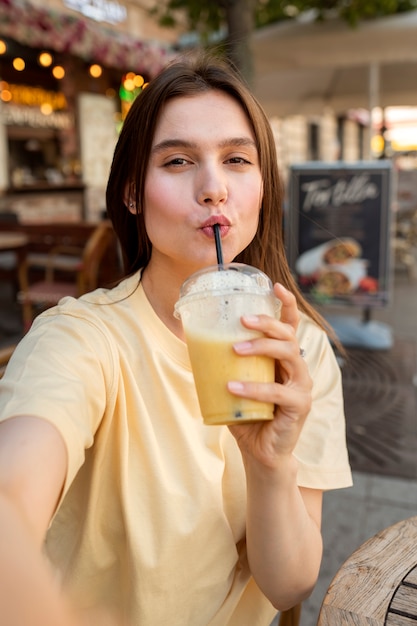 Medium shot woman posing with drink