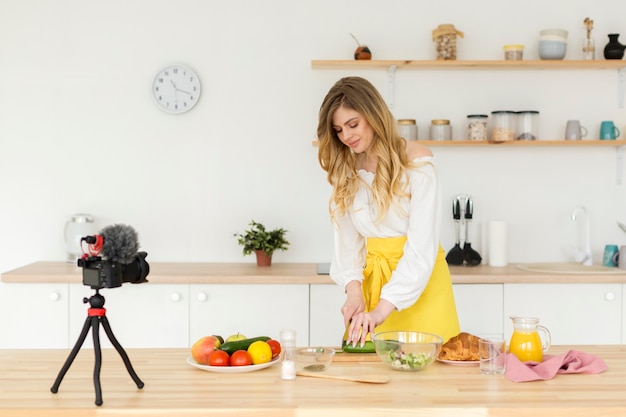 Medium shot woman recording in kitchen