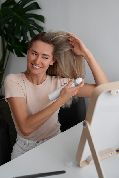 Medium shot woman using dry shampoo at home