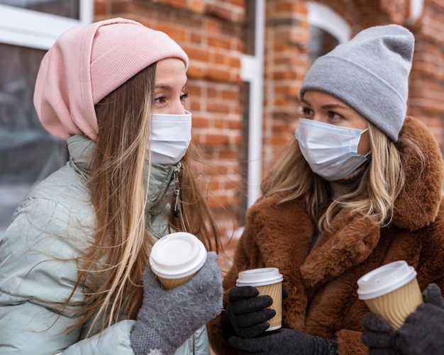 Medium shot women holding coffee cups