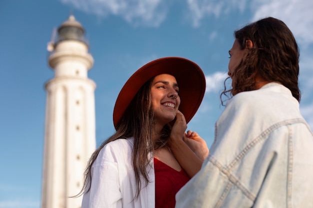 Medium shot women posing with lighthouse