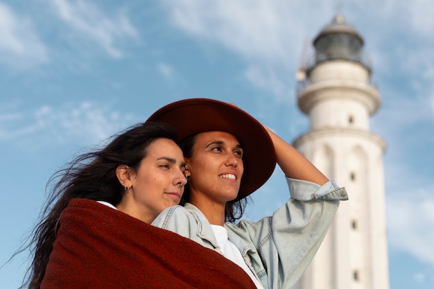 Medium shot women posing with lighthouse