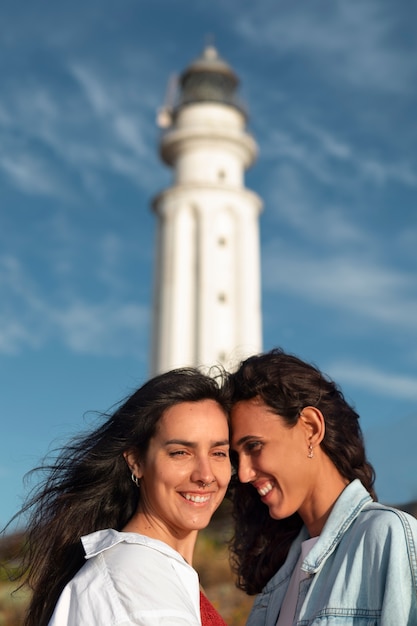 Medium shot women posing with lighthouse