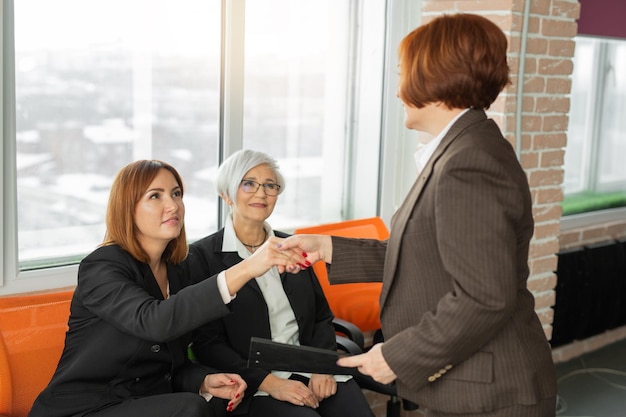 meeting of adult beautiful women at work with handshake