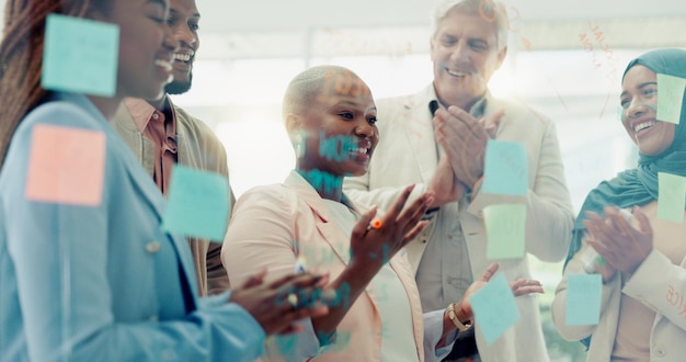 Meeting planning and sticky notes on glass in the office with a diversity business team planning strategy Teamwork collaboration and coaching with a black woman leader teaching her staff at work