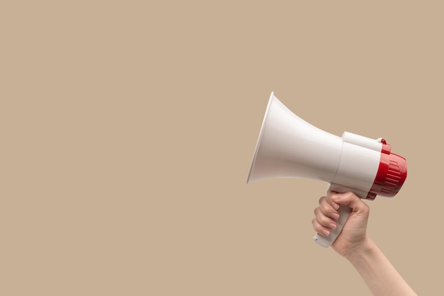 Megaphone in woman hands on a white background