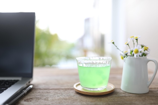 Melon Juice and notebooks and laptop flower on wooden table