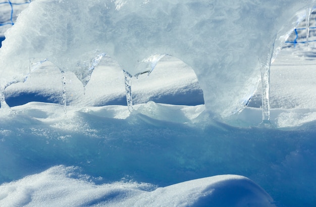 Melting glacial block of ice with icicles closeup.