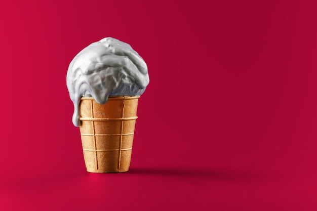 Melting metallic ice cream in a gold cup on a red background Creative concept for a premium sale