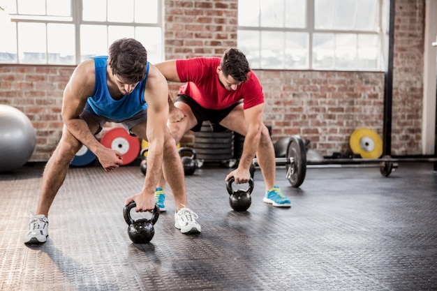 Men doing exercise with kettlebell