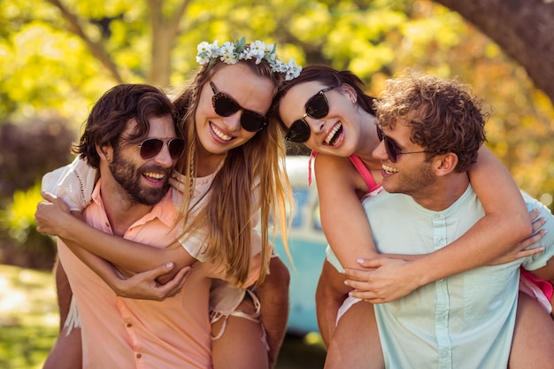 Men giving piggyback rides to women