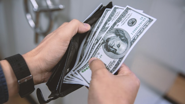 Men hand picking a dollar in a pocket.