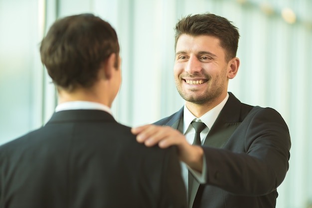 The men hold on the shoulder in the office