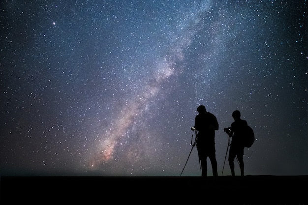 Men photographer standing near the camera and taking photo milky way and stars