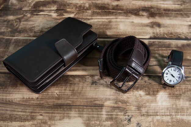 Men's accessories with brown leather walletwatch on wood