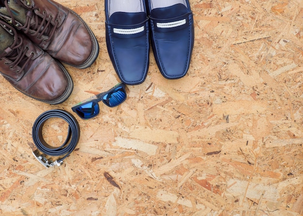 Men's casual outfits with leather accessories on wooden background, fashion concept.