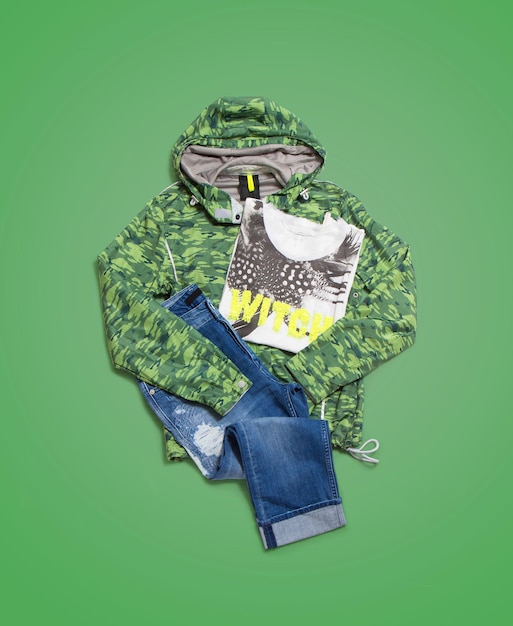 Men's casual street clothes on green background. Sweatshirt , T-shirt and jeans