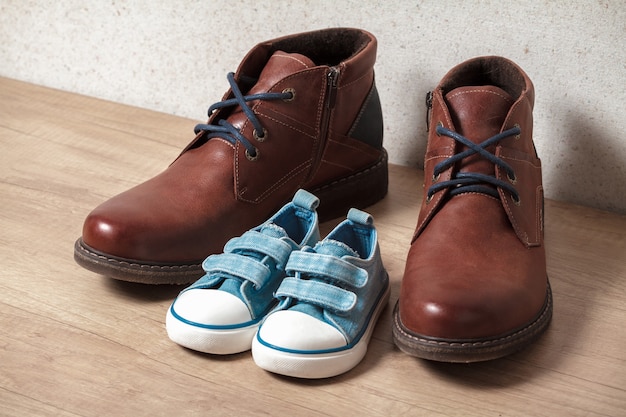 Men's and children's shoes on a wooden floo