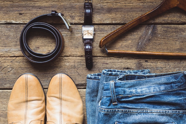 Men's clothes and accessories on wooden background. Top view