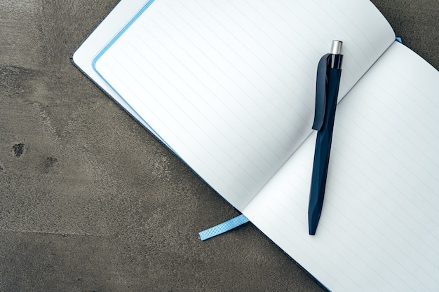 Men's diary and pen on dark grey background close up